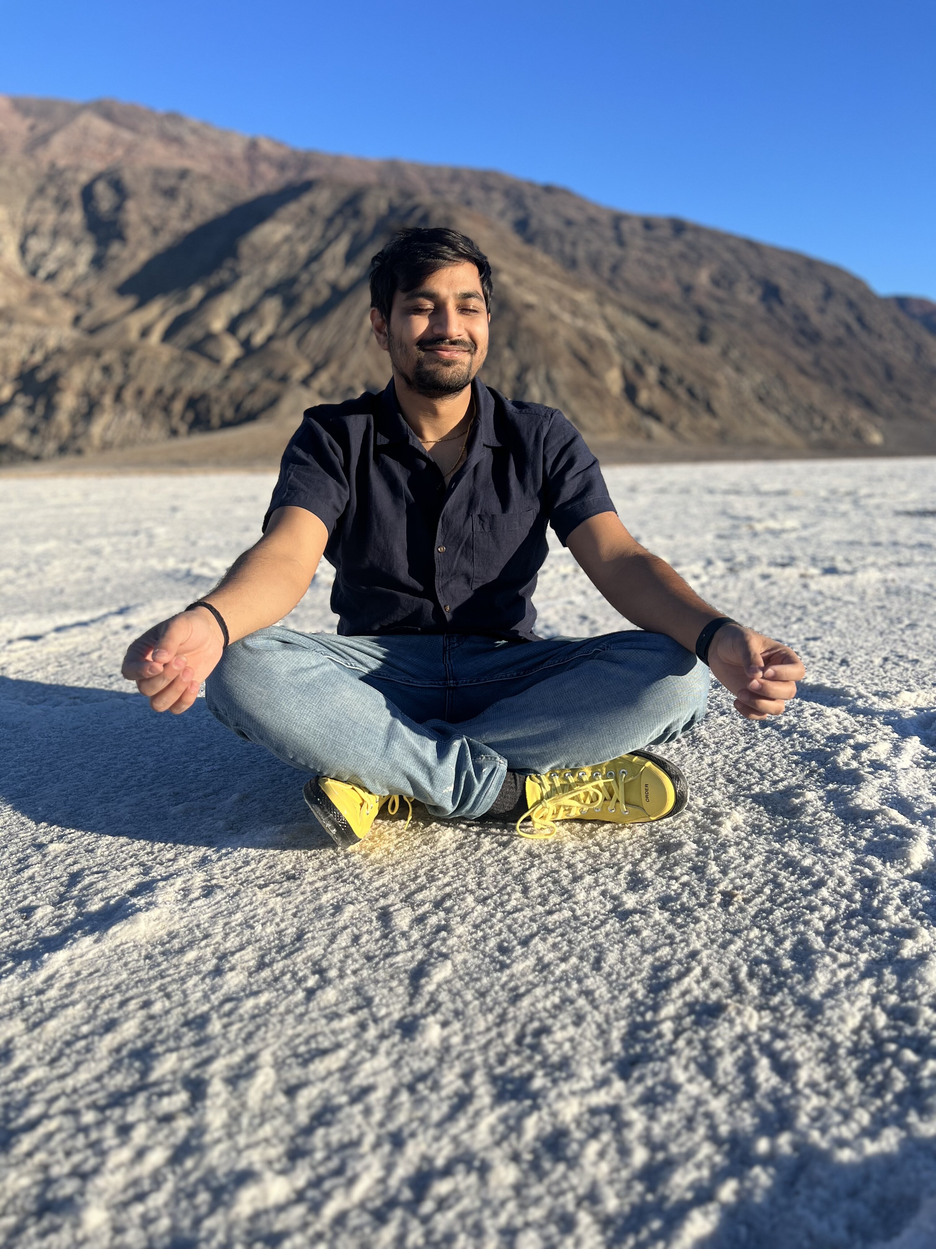 Vividh meditating cross-legged on white salt flats
